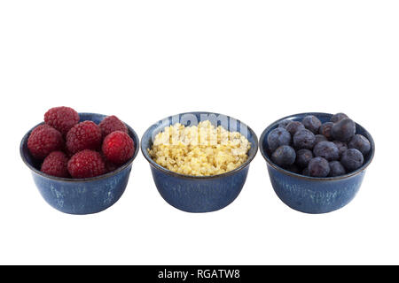 Kleine Schüsseln mit gesunden Snacks: Himbeeren, gekochte Quinoa und Blaubeeren mit Ausschnitt auf weißem Hintergrund Stockfoto