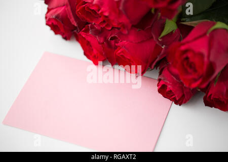 Nahaufnahme von roten Rosen und Brief oder Hinweis Stockfoto