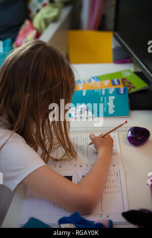 Junge Mädchen im Alter von 10 ihr Mathe Hausaufgaben am Schreibtisch Stockfoto