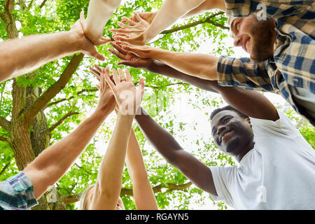 Happy Gruppe von Freunden macht hohe fünf Unterstützung zusammen Stockfoto