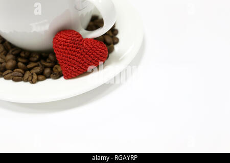 Romantisches Frühstück auf Valentinstag, Tasse Kaffee, Rot gestrickt, Herz und Kaffeebohnen isoliert auf Weiss. Konzept der Liebe, glückliche Morgen Stockfoto