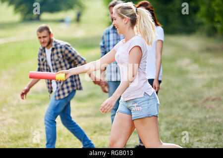 Junge Frau Hände den Staffelstab in einem Staffellauf am Teambuilding workshop Stockfoto