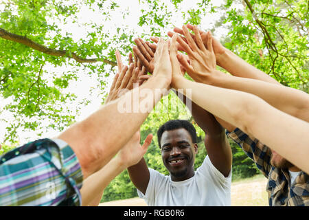 Team stellt hohe Fünf für Motivation und Integration im Workshop zur Teamentwicklung Stockfoto