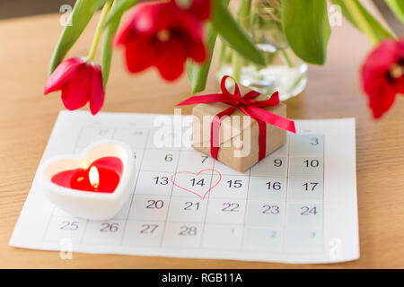 Geschenkbox, Kalenderblatt und Blumen auf dem Tisch Stockfoto