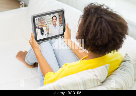 Frau mit video chat mit Apotheker auf Tablet Stockfoto
