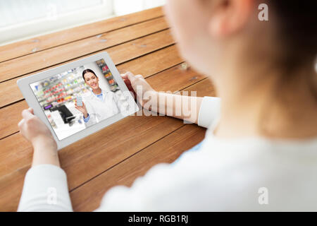 Frau mit video chat mit Apotheker auf Tablet Stockfoto