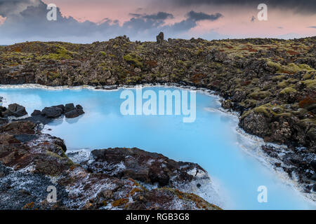 Dramatische Landschaft eines schönen vulkanische Terrain mit schwarzen vulkanischen Felsen und türkisem Wasser an der Blauen Lagune bei Grindavik in Reykjanes Halbinsel Stockfoto