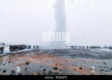 Die Menschen in der schweren Winter Schneefall, warten auf den Ausbruch des Strokkur Geysir in Island Stockfoto