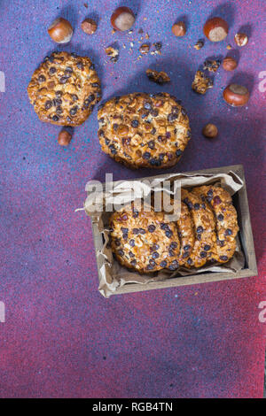 Avena cookies mit Haselnüssen und Schokolade, Chips und eine Box mit Cookies Stockfoto