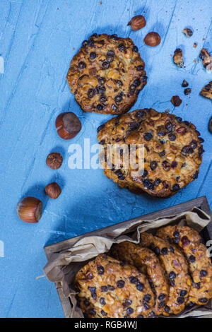Avena cookies mit Haselnüssen und Schokolade, Chips und eine Box mit Cookies Stockfoto