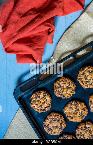 Avena cookies mit Haselnüssen und Chocolate Chips auf ein Backblech und einige Tücher Stockfoto