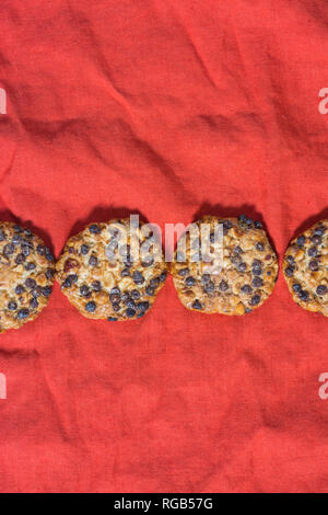 Avena cookies mit Haselnüsse und Schokolade Chips auf einem roten Tuch Stockfoto