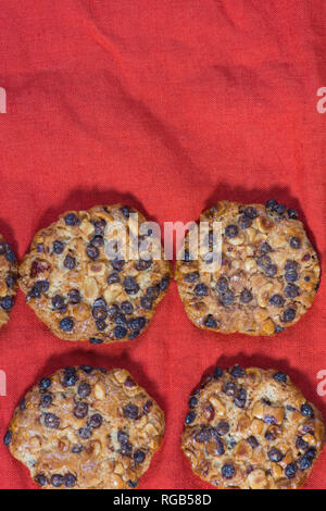 Avena cookies mit Haselnüsse und Schokolade Chips auf einem roten Tuch Stockfoto