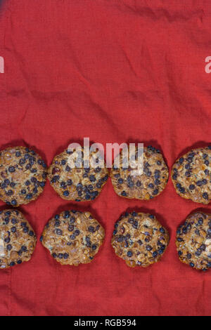 Avena cookies mit Haselnüsse und Schokolade Chips auf einem roten Tuch Stockfoto
