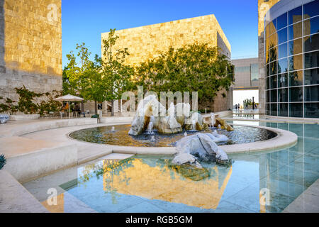 Juni 8, 2018 Los Angeles/CA/USA - Brunnen im Museumshof des Getty Center bei Sonnenuntergang; Travertin bedeckte Wand, durch Th beleuchtet Stockfoto