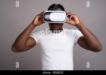 Junge schöne afrikanischer Mann mit Virtual reality Headset gegen Stockfoto
