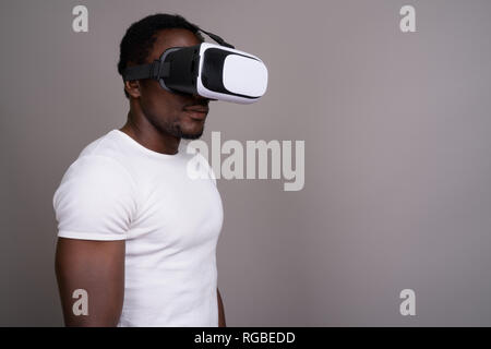 Junge schöne afrikanischer Mann mit Virtual reality Headset gegen Stockfoto