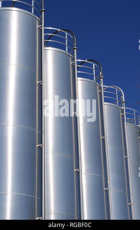 Silos aus Edelstahl in der chemischen Industrie, massenkunststoffe Silo vor blauem Himmel Stockfoto