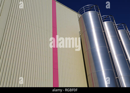 Silos aus Edelstahl in der chemischen Industrie, massenkunststoffe Silo vor blauem Himmel Stockfoto