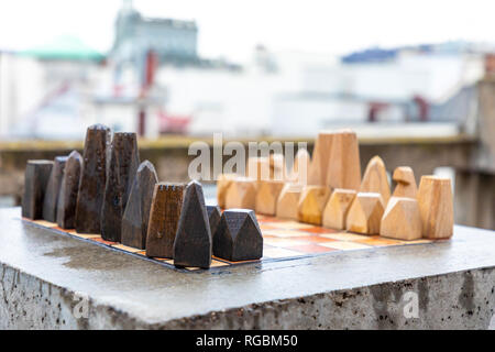 Eine Reihe von Stein handgefertigten Holzmöbeln Schach auf steinernen Tisch in home Outdoor, bevor das Spiel beginnt Stockfoto