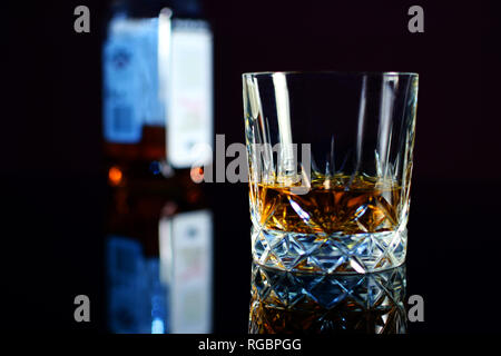 Whiskey in Kristallglas. Auf dem Hintergrund der Flasche. Stockfoto