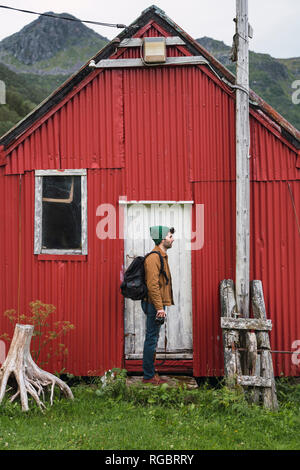 Junger Mann, der vor Wellblech shack Stockfoto