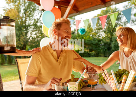 Glückliches Paar einander gegenüber auf einer Gartenparty Stockfoto