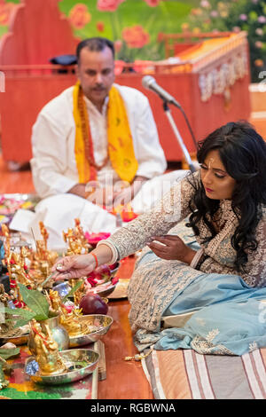 Eine schöne fromme Hindu worshipper feiert ihren Geburtstag durch Unterstützung im Morgengebet Service. In Richmond Hill, Queens, New York City. Stockfoto