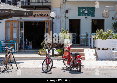 RETHYMNO, Griechenland - AUGUST 2018: Fahrräder und Mopeds sind einem Aufenthalt in der Nähe von traditionellen griechischen Taverne auf Kreta geparkt Stockfoto