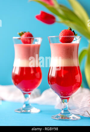 Italienische dessert Panna Cotta mit Erdbeeren auf blauen Hintergrund in Valentines Tag Stockfoto