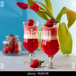 Italienische dessert Panna Cotta mit Erdbeeren auf blauen Hintergrund in Valentines Tag Stockfoto