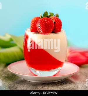 Italienische dessert Panna Cotta mit Erdbeeren auf blauen Hintergrund in Valentines Tag Stockfoto