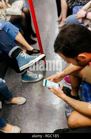 UK, London, Mann in der U-Bahn an der Zelle Telefon Stockfoto
