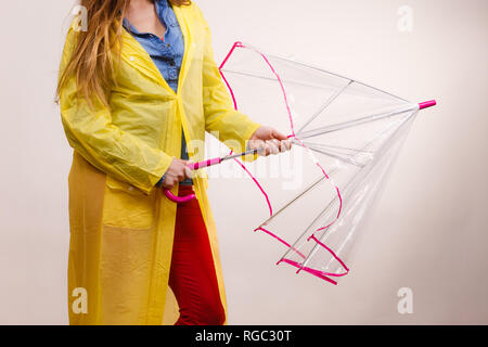 Frau modische regnerischen Mädchen tragen Wasserdicht gelb transparent Regenschirm öffnen Studio shot Stockfoto