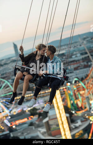 Junges Paar in Liebe, Reiten auf einem Rummelplatz chairoplane Stockfoto