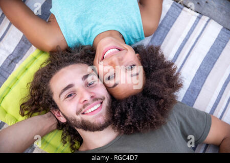 Portrait von glücklichen Paares liegen auf einer Decke im Freien Stockfoto