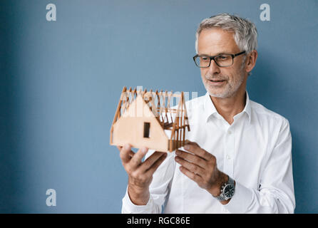 Erfolgreiche Architekt bei Modell eines Hauses suchen Stockfoto