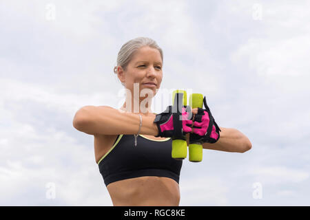 Reife Frau tun Training mit Hanteln im Freien Stockfoto