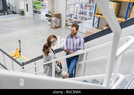 Busenessman und Frau auf Treppe in Unternehmen, Reden Stockfoto