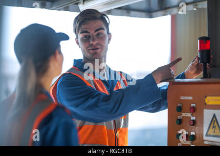 Zwei Arbeiter tragen Overalls und reflektierende Jacken Stockfoto