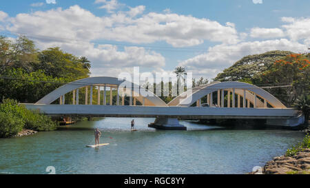 HALEIWA, VEREINIGTE STAATEN VON AMERIKA-Am 12. Januar 2015: Paddel Boarder unter der Brücke in Haleiwa, Hawaii Stockfoto