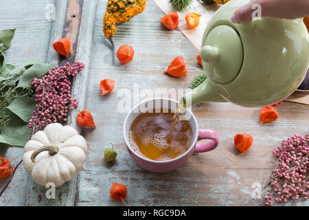 Woman's Hand gießt Kaffee in eine Tasse Stockfoto