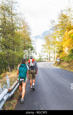 Italien, Massa, Rückansicht des Junges Paar geteerte Straße in die Apuanischen Berge Stockfoto