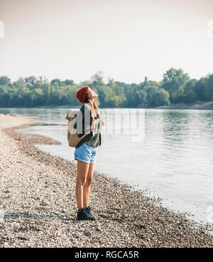 Glückliche junge Frau, die am Flußufer Stockfoto