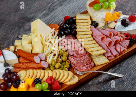 Auswahl an verschiedenen Sorten Käse, Cracker, Trauben, Nüsse, Oliven in den Wald Hintergrund Stockfoto