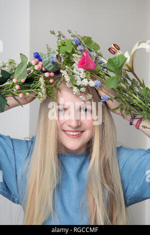 Portrait von lächelnden blonde Mädchen mit Blumen Stockfoto