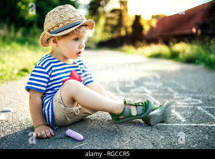 Tagträumen Kleinkind Junge sitzt auf der Straße Stockfoto