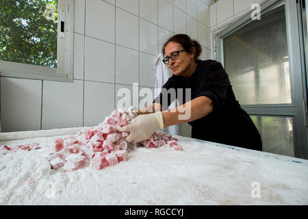 Die Herstellung und Verpackung Loukoumi, Turkish Delight in Zypern. Die Beschichtung der Süßigkeit in Puderzucker. Stockfoto