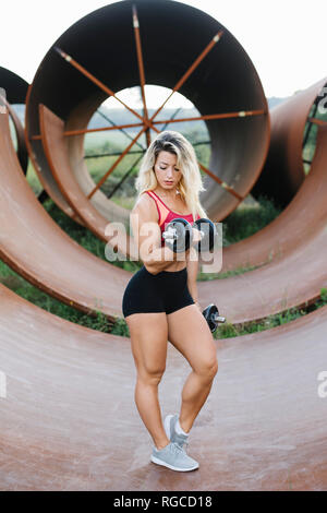 Athletische Frau tun Gewicht Workout an Industrial Site Stockfoto