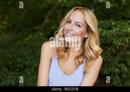 Porträt von lächelnden blonden Frau im freien Stockfoto